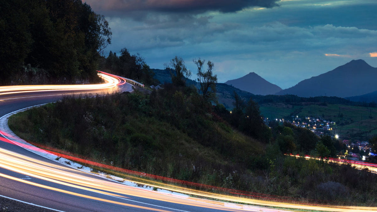 Light trails trace a series of sweeping bends at dusk